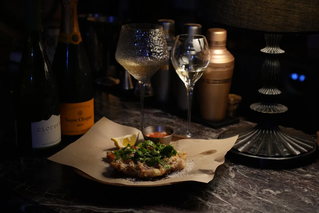 シャンパンとワイングラスのそばに置かれた料理